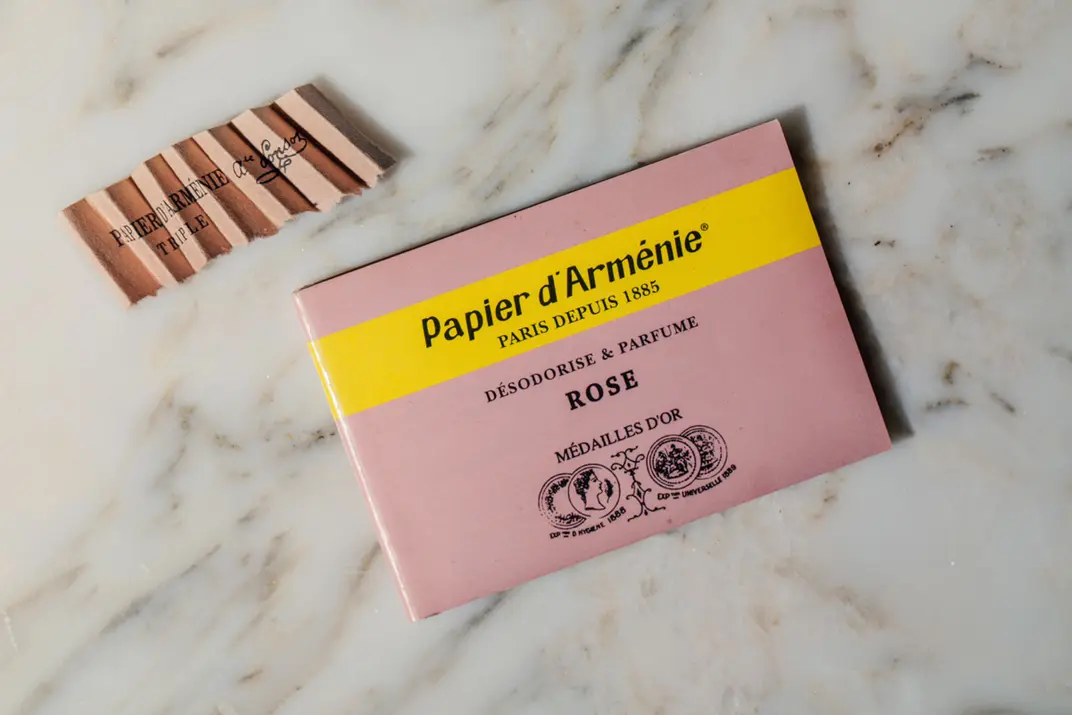 Розовая упаковка армянской бумаги papier d’Armenie лежит на столе