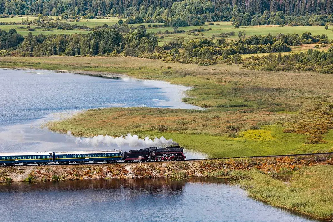 Вид сверху на ретропоезд Ruskeala Express, который едет вдоль озера
