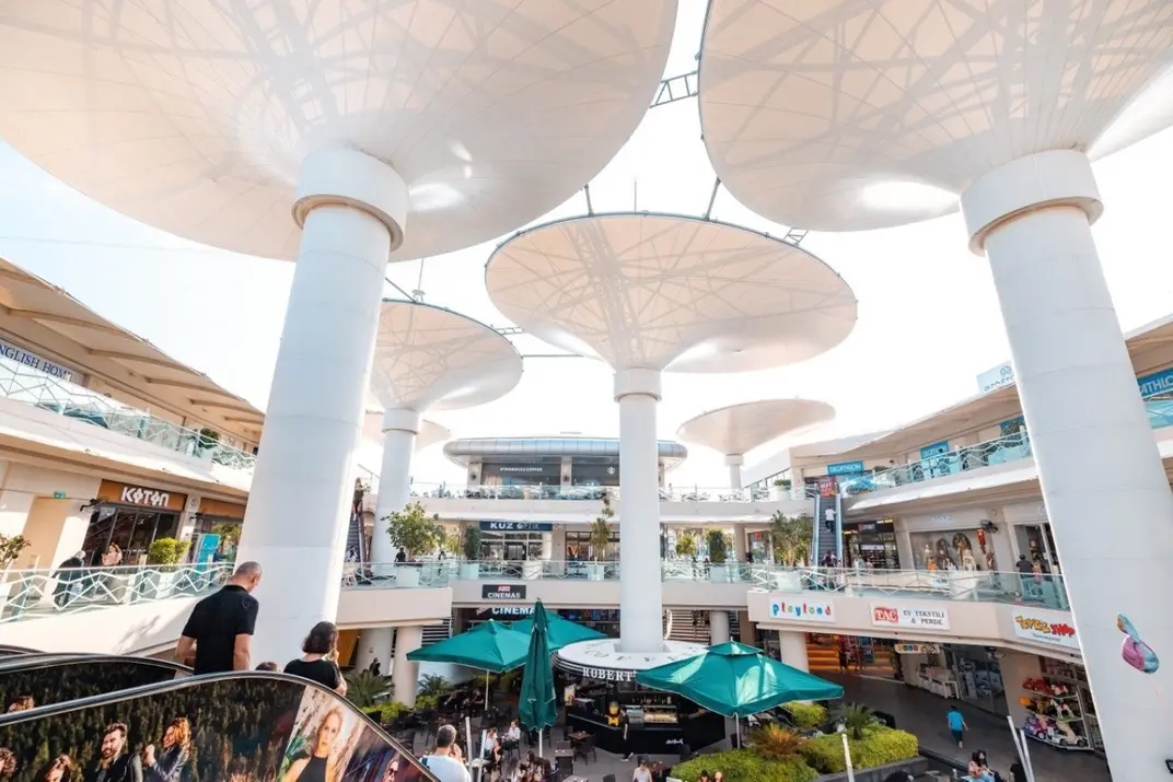 Необычный интерьер современного торгового центра Erasta Mall без крыши, с футуристическими колоннами в виде деревьев и магазинами