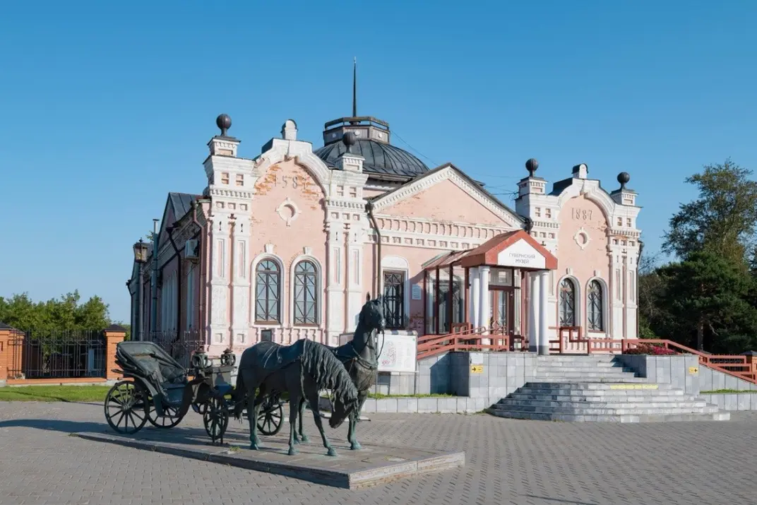 Скульптура Пара коней запряженных в экипаж на фоне Губернского музея в Тобольске