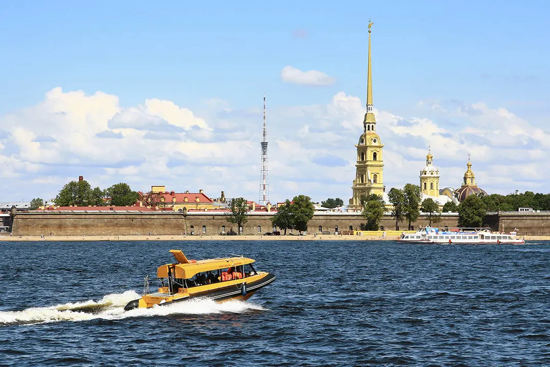 Желтое водное такси идет по Неве на фоне Петропавловской крепости