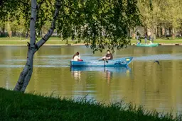 Люди катаются на лодке в московском парке Победы